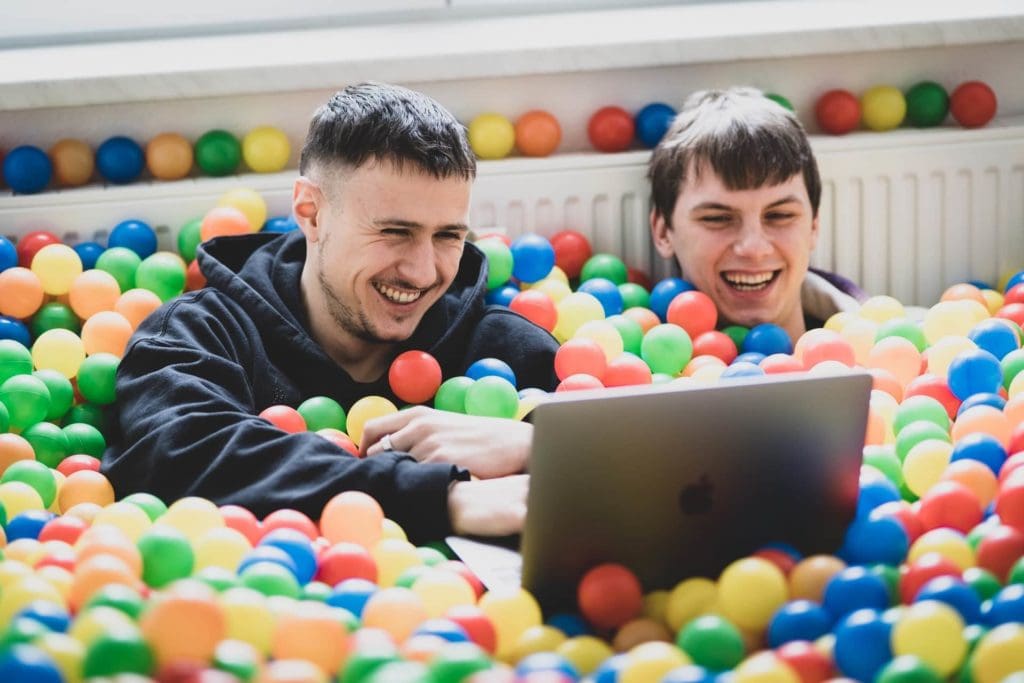 Zwei Mitarbeiter arbeiten gut gelaunt im Bällebad