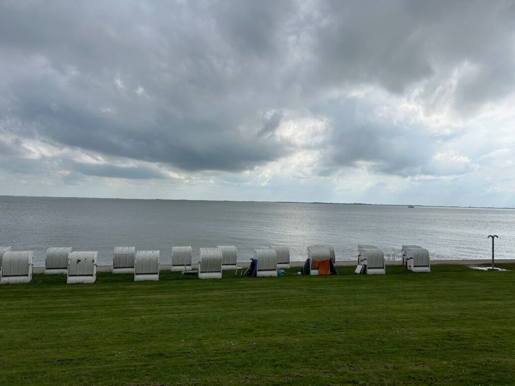 Küste mit Strandkörben und Wolken