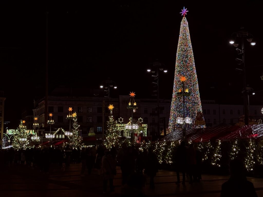 Beleuchteter Weihnachtsbaum auf einem stimmungsvollen Weihnachtsmarkt