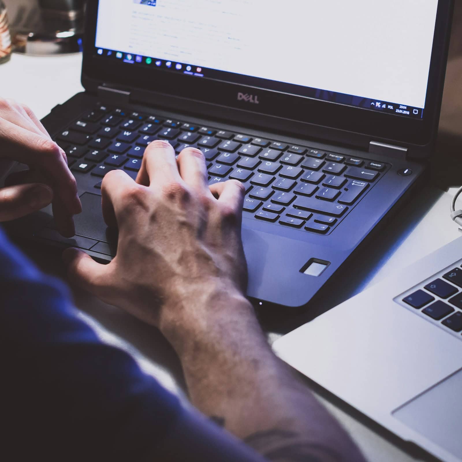 Person tippt auf Laptop-Tastatur.