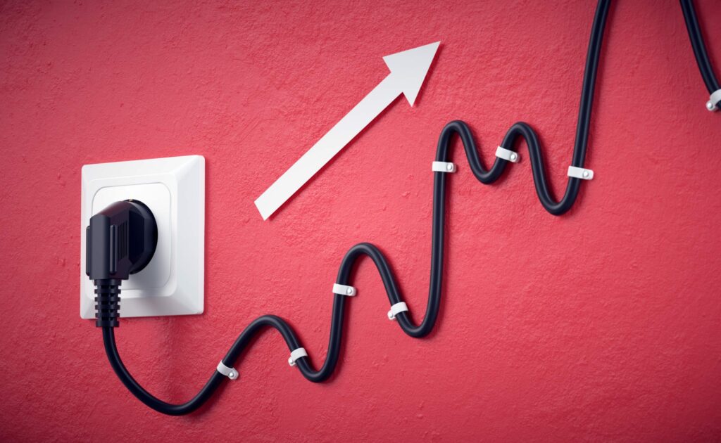 Foto zeigt ein Kabel in einer Steckdose an der Wand, das Kabel geht von der Steckdose wellenförmig nach oben. Zusätzlich zeigt ein Pfeil nach oben. Foto von Negro Elkha (stock.adobe.com).
