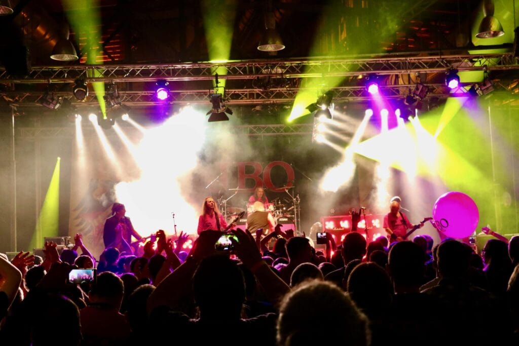 Band auf Bühne bei Konzert mit Fans.